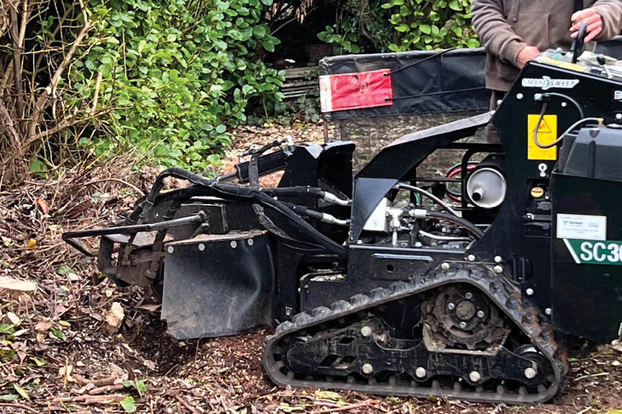 A tree stump being removed in Devon with professional machinery, with works carried out by PLG Services
